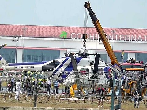 An ALH Dhruv Mark 3 helicopter of the Indian Coast Guard (ICG) being carried by crane after it met with an accident near the main runway during chopper testing, at Cochin International Airport, in Kochi on Sunday, March 26, 2023.
