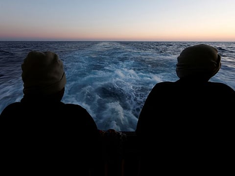 Rescued migrants look out to sea on the Geo Barents rescue ship, operated by Medecins Sans Frontieres (Doctors Without Borders), as the ship makes its way to the Italian port of Bari, in the central Mediterranean Sea March 25, 2023. REUTERS/Darrin Zammit Lupi