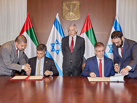 Benjamin Netanyahu witnesses the signing of the agreement at the Prime Minister’s office in Jerusalem.
