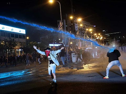 Israeli security forces use water canons to disperse protesters during ongoing demonstrations in Tel Aviv on March 27, 2023.