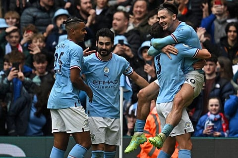 Manchester City's midfielder Jack Grealish (right) celebrates with teammates after scoring their fourth goal during the English Premier League match against Liverpool at the Etihad Stadium in Manchester, north west England.