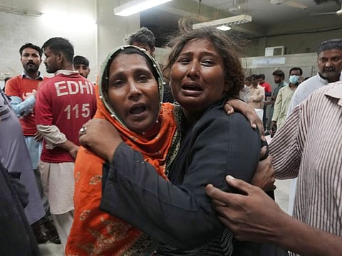 Women mourn over the death of their family member, who was died in the stampede, at a morgue, in Karachi.