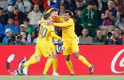 Barcelona forward Robert Lewandowski (centre) celebrates with Gavi (left) and Jules Kounde after scoring his team's third goal during the Spanish league match against Elche CF at the Martinez Valero stadium in Elche.