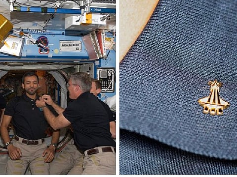 Sultan Al Neyadi receiving the pin from NASA SpaceX Crew-6 commander Stephen Bowen on International Space Station
