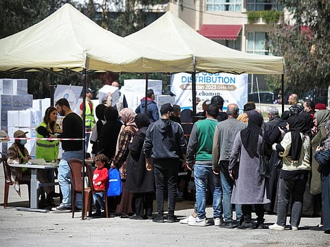 People wait to receive food aid, during Ramadan in Beirut on April 3, 2023. Since late 2019, Lebanon has faced a devastating economic crisis that has plunged more than 80 per cent of the population into poverty, according to the United Nations.