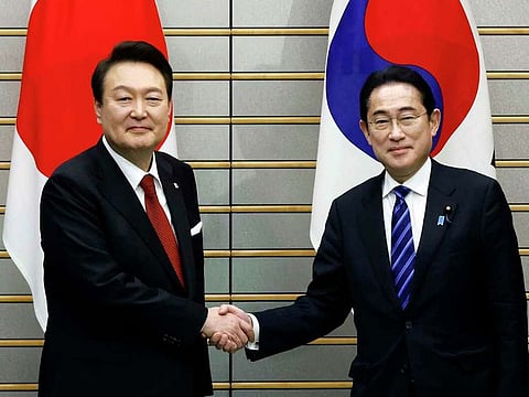 South Korean President Yoon Suk Yeol, left, and Japanese Prime Minister Fumio Kishida, right, shake hands, ahead of their bilateral meeting at the Prime Minister's Office, in Tokyo, Japan, Thursday, March 16, 2023