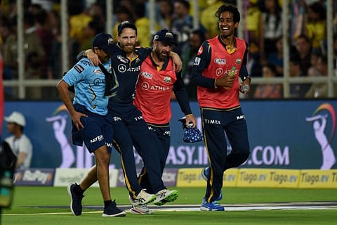 Gujarat Titans' Kane Williamson (centre) is helped by teammates back to the pavillion after he injured his knee.