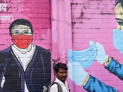A man walks past a COVID-19 themed mural on a street in Mumbai, India.