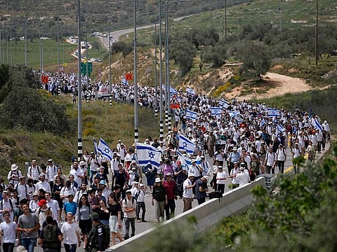 People march to the outpost of Eviatar near Tapuah junction, West Bank, Monday, April 10, 2023.