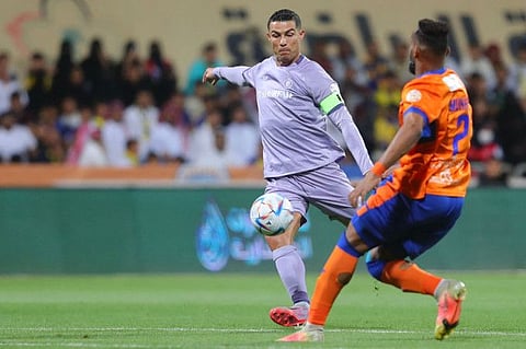 Al Nassr's Portuguese forward Cristiano Ronaldo (left) attempts a shot during the Saudi Pro League match against Al Fayha at the al-Majmaah stadium in the city of al-Majmaah. The match ended 0-0.