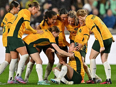 Australia's defender Charlotte Grant (bottom) is mobbed by teammates after scoring the team's second goal during the International friendly match against England at the Gtech Community Stadium in Brentford, west London.