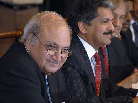 Late Keshub Mahindra, left, vice-chairman of Mahindra & Mahindra Ltd, Anand Mahindra, chairman, second left, react at the company annual general meeting in Mumbai. (File photo)