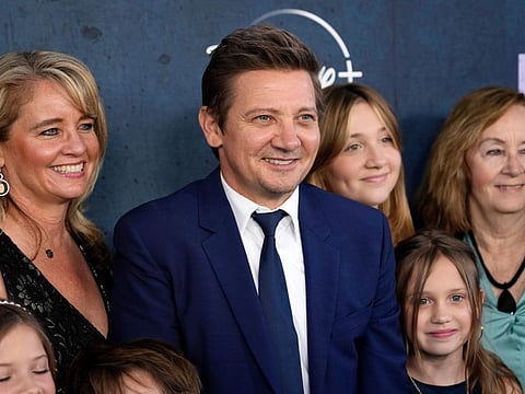 Jeremy Renner, center, the host and executive producer of "Rennervations," is surrounded by family members at the premiere of the four-part Disney+ docuseries, Tuesday, April 11, 2023, at the Westwood Regency Village Theatre in Los Angeles. The premiere marked Renner's first public, in-person appearance since a Jan. 1 snow plow accident outside his Reno, Nev., home left him with life-threatening injuries. (AP Photo/Chris Pizzello)