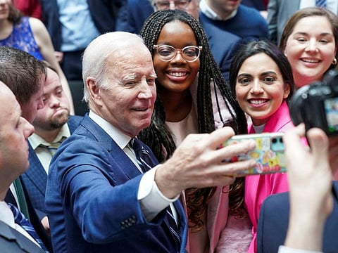US President Joe Biden takes a selfie with students follwing the 25th anniversary of the Belfast/Good Friday Agreement, at Ulster University, Belfast, Northern Ireland April 12, 2023.