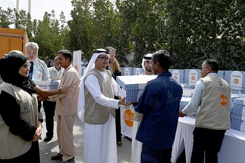 Dawoud Al Hajri, Deputy Chairman of the Board of Trustees of the UAE Food Bank, handing over food basket to needy people.