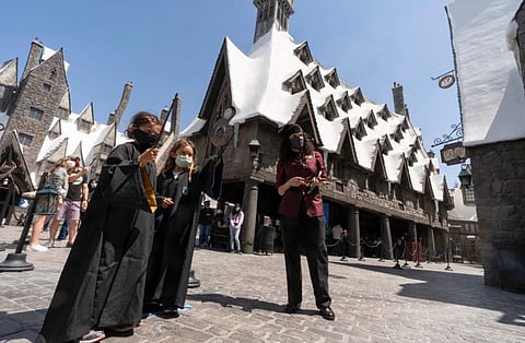 Campbell Chang, 6, and Juliana Single, 6, wear face masks as they cast their spells at Wizarding World of Harry Potter at Universal Studios Hollywood theme park in Los Angeles, on April 16, 2021. Warner Bros. Discovery is sticking with safe bet franchises that will likely lure viewers, including a “Harry Potter” series and a “Game of Thrones” prequel for its rebranded Max streaming service, the company announced Wednesday, April 12, 2023.
