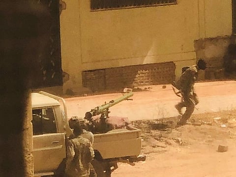 A military vehicle and soldiers said to be from the Sudanese armed forces are seen on a street in Khartoum on April 15, 2023 in this picture screen grab obtained from a social media video.