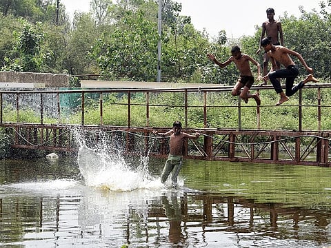 Children jump in Kondli canal to beat the scorching heat, in New Delhi on Saturday.
