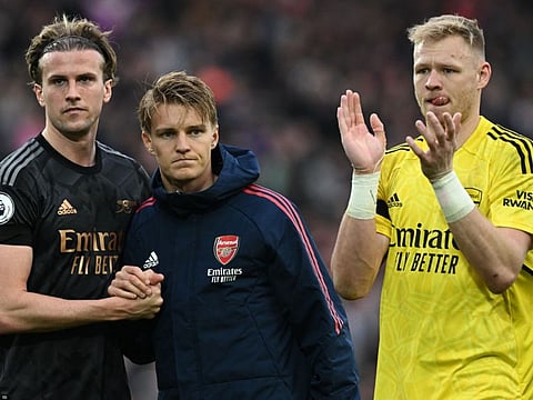 Arsenal defender Rob Holding (left), midfielder Martin Odegaard (centre) and goalkeeper Aaron Ramsdale applaud the fans after drawing 2-2 against Liverpool last weekend. Arsenal face West Ham on Sunday and cannot afford to drop more points if they are to win the title.