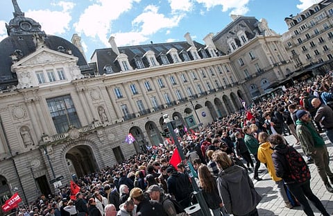Protesters gather outside Place de la Republique to demonstrate against the French Government's pension reform hours after it was signed into law in Rennes, western France, on April 15, 2023.