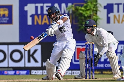 Sri Lanka's Kusal Mendis (left) plays a shot as Ireland's wicketkeeper Lorcan Tucker watches during the first day of the first Test at the Galle International Cricket Stadium in Galle.