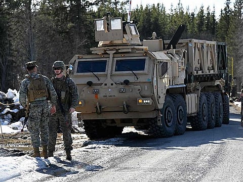 Members of the US Marine Corps (L) and Swedish troops as seen during the start of the defence exercise Aurora 23 near Ostersund on April 17, 2023.