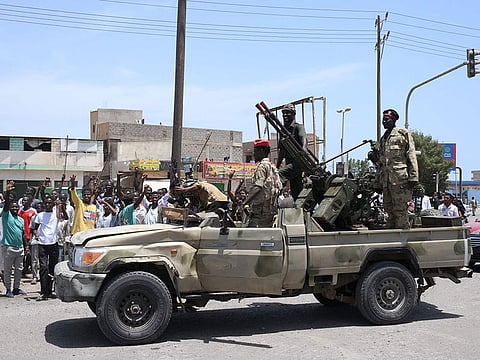 Sudanese greet army soldiers, loyal to army chief Abdel Fattah Al Burhan, in the Red Sea city of Port Sudan on April 16, 2023.