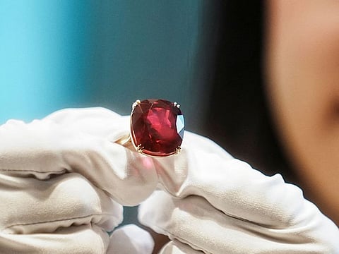 An employee poses with the 55.22 carat "The Estrela de Fura" ruby, the largest in the world and expected to fetch up to $30 million in an upcoming New York auction, during a preview at Sotheby's, in Hong Kong, China April 17, 2023.