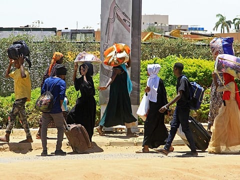 People flee from southern Khartoum on April 18, 2023 as fighting between the army and paramilitary forces led by rival generals raged for a fourth day before the start of ceasefire..