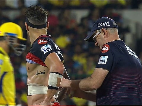 Faf du Plessis showing his tattoo in Urudu, which reads Fazal, while getting treatment for his strained ribs during Bangalore's match against Chennai on Monday.