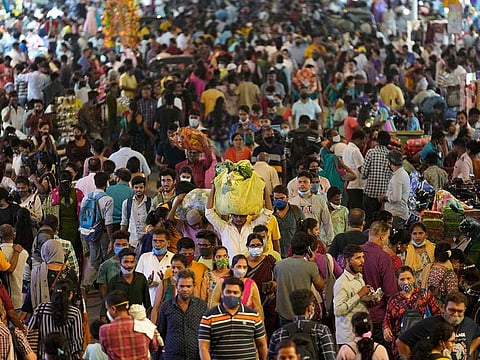People crowd a market area outside a train station in Mumbai, India, Saturday, March 12, 2022.