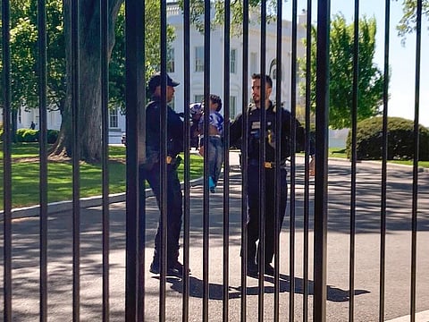 US Secret Service Uniformed Division police officers carry a young child who crawled through the White House fence on Pennsylvania Avenue in Washington, on Tuesday.