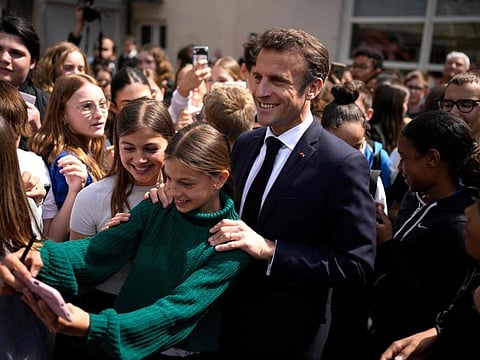 French President Emmanuel Macron poses for a selfie with school children as he visits a middle school, in Ganges, southern France, on April 20, 2023.