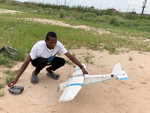 Bolaji Fatai prepares to fly a model aeroplane made from discarded waste, in Lagos, Nigeria.