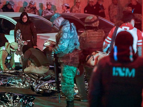 Authorities work at the site of a deadly fire at an immigration detention center, where covered bodies lie on the ground in Ciudad Juarez, Mexico.