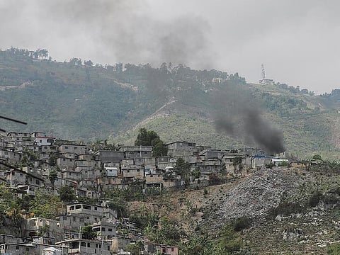 Smoke rises between houses in the Debussy neighbourhood during clashes between gangs, in Port-au-Prince, Haiti.