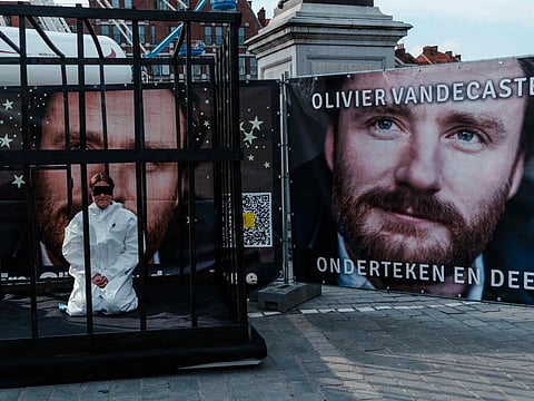 Belgian Manon Vandecasteele sits blindfolded in a cell during a protest action for her uncle Olivier Vandecasteele, who is imprisoned in Iran, on the Grand-Place in Tournai on April 22, 2023.