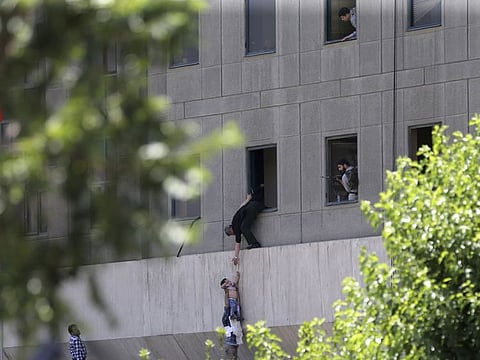 A man hands a child to a security guard from Iran's parliament building after an assault of several attackers, in Tehran, Iran on June 7, 2017.