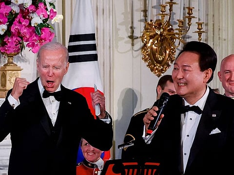 U.S. President Joe Biden reacts as South Korea's President Yoon Suk Yeol sings at an official state dinner.