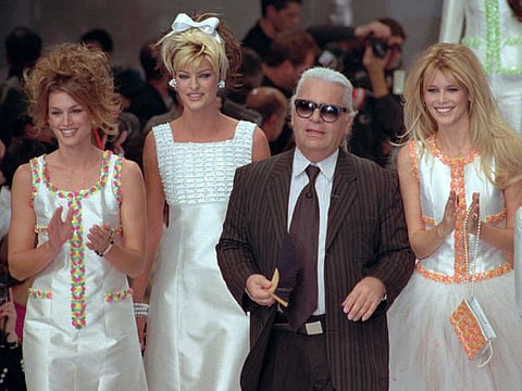 File photo of German designer Karl Lagerfeld joins models, from left, American Cindy Crawford, Canadian Linda Evangelista and Claudia Schiffer of Germany after the presentation of his 1996 spring-summer ready-to-wear fashion collection for Chanel in Paris on October 19, 1995.
