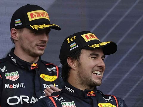 Sergio Perez celebrates on the podium after winning the race along with second placed Red Bull's Max Verstappen