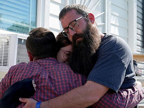 A reporter embraces Ashley and Justin Webster, the parents of Ivy Webster in Henryetta, Oklahoma.