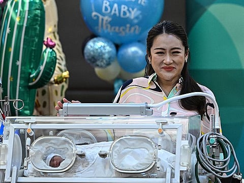 Pheu Thai Party candidate Paetongtarn Shinawatra, youngest daughter of former Thai prime minister Thaksin Shinawatra, presents her newborn son Thasin (L) in an incubator while addressing media representatives at the Praram 9 hospital in Bangkok on May 3, 2023.