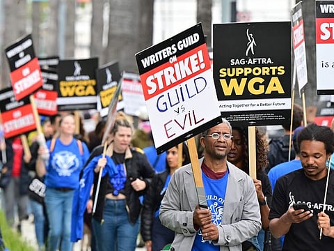 Writers on strike march with signs on the picket line on day four of the strike by the Writers Guild of America in front of Netflix in Hollywood, California on May 5, 2023.