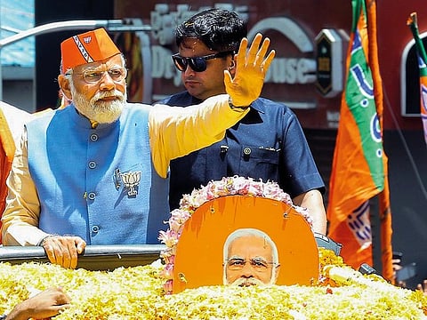Prime Minister Narendra Modi waves as he holds a roadshow in Karnataka’s Bengaluru on Saturday.