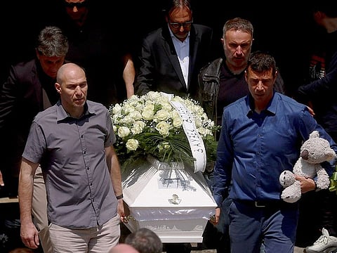 Family members carry the coffin of Ema Kobiljski, 13, during the funeral procession at the central cemetery in Belgrade, Serbia, Saturday, May 6, 2023.