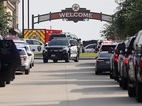 Emergency vehicles line the entrance to the Allen Premium Outlets where a shooting took place.