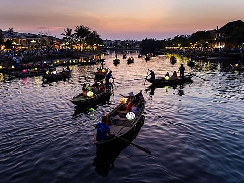 Tourists ride boats along the Thu Bon River in the old town of Hoi An, Qung Nam Province, Vietnam.