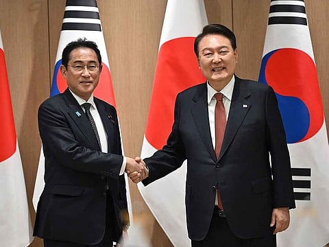 South Korean President Yoon Suk Yeol (right) shakes hands with Japanese Prime Minister Fumio Kishida during their meeting at the presidential office in Seoul on May 7, 2023.