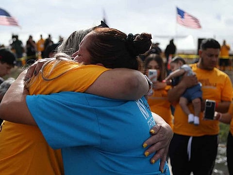 Migrants embrace during the 'Hugs, No Walls' event organised by the US organisation Border Network for Human Rights in the middle of the Rio Grande, on the border between El Paso, Texas state, United States, and Ciudad Juarez, Chihuahua state, Mexico, on May 6, 2023.